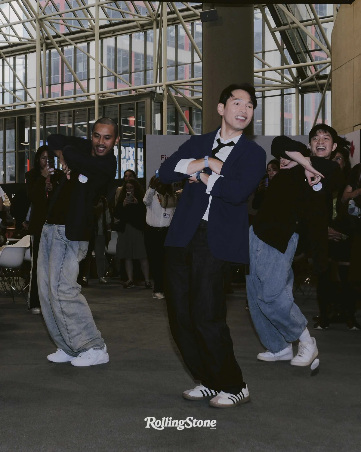 Jonathan Wong and two castmates dancing in front of a crowd at the TIFF market screening, photographed for Rolling Stone Canada